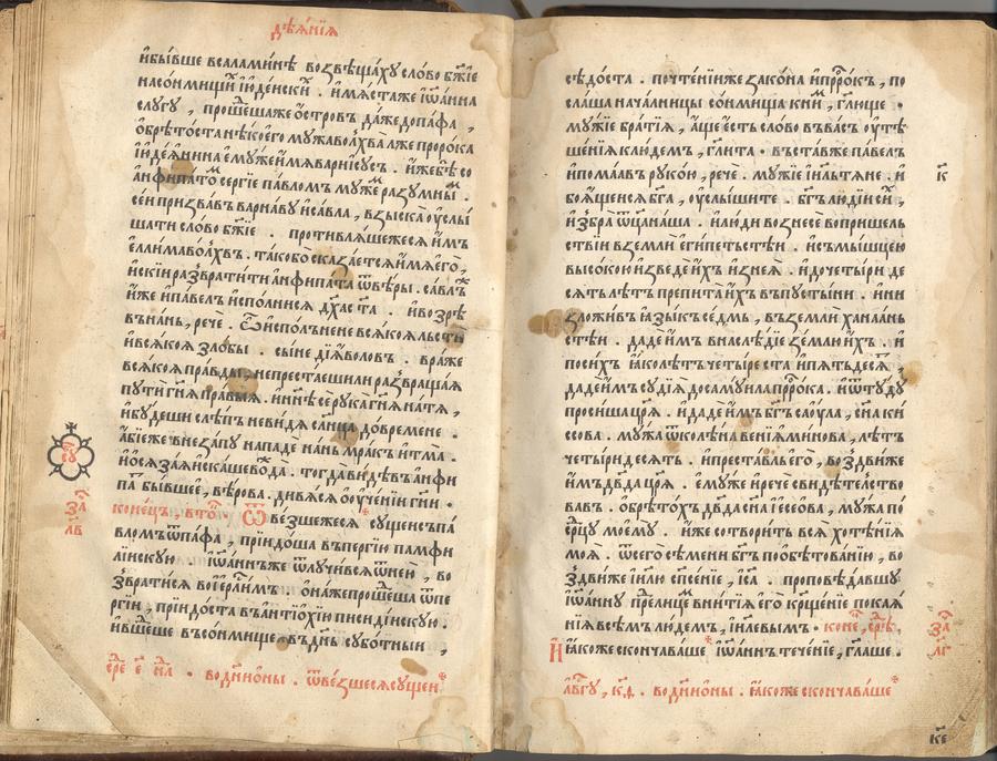 Раскрытая старинная книга: две страницы плотного церковнославянского набора чёрными буквами, заголовки и отдельные буквы выделены красным