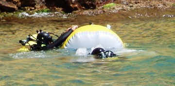 Водолазы поднимают груз с помощью надувного подъёмного мешка