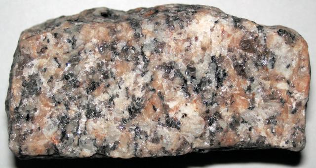 Серо-розовый камень в мелкую чёрную и белую крапинку